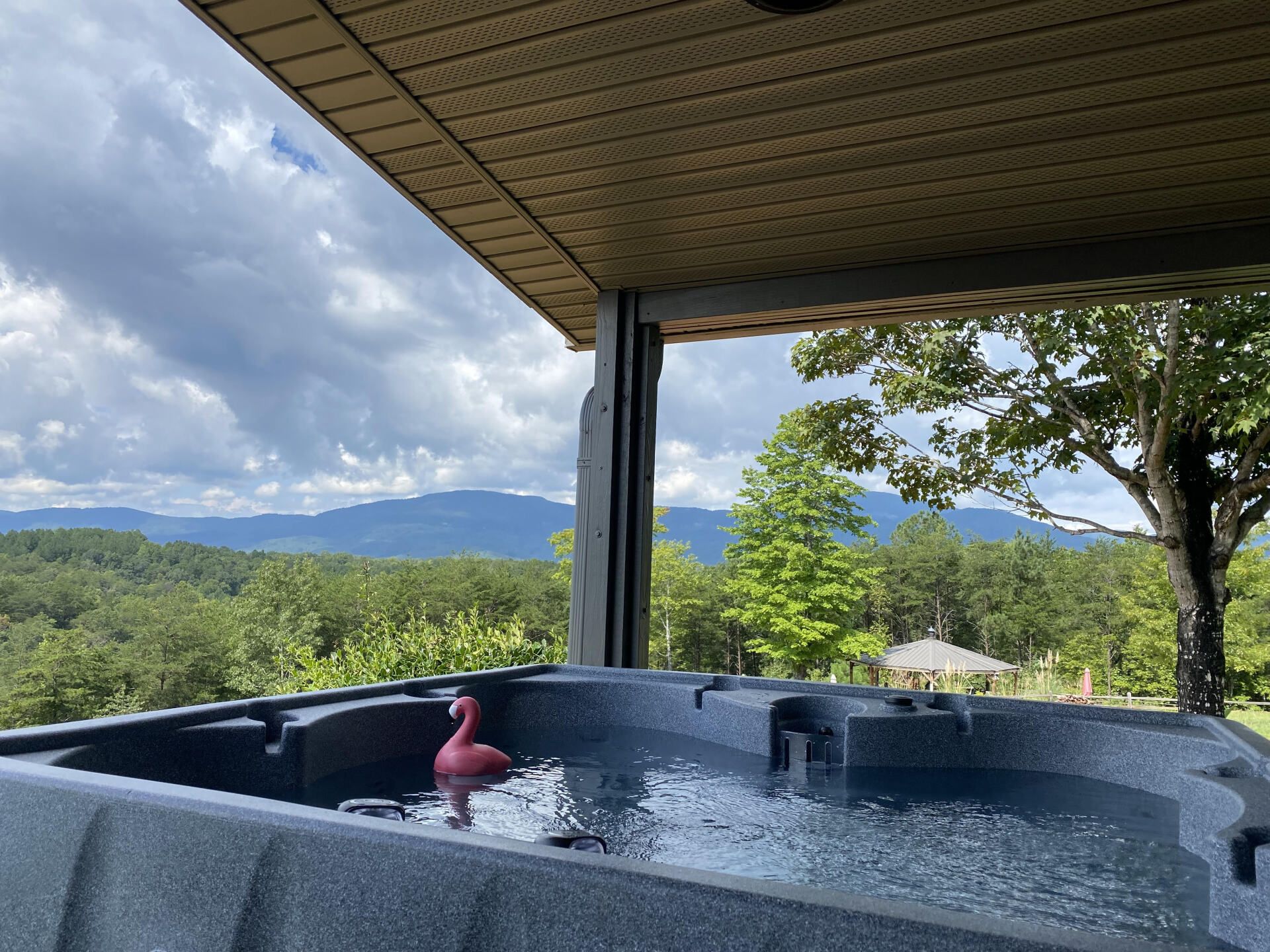 Hot tub on porch overlooking mountains at Hilltop House Serenity Ridge