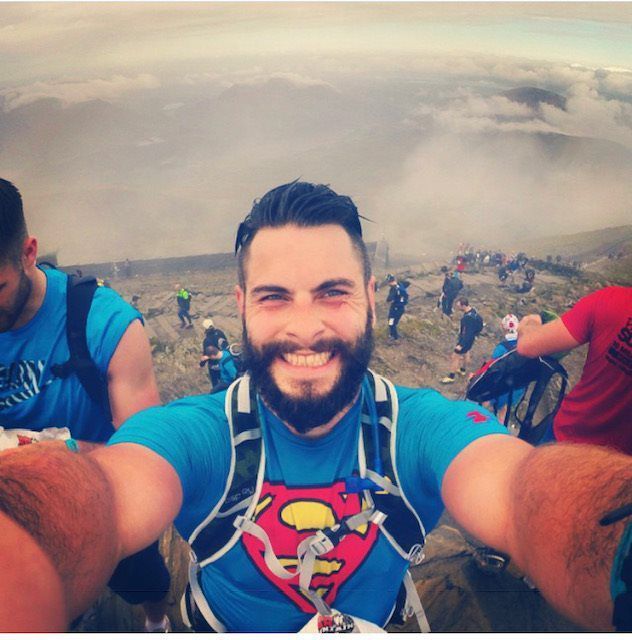 A man wearing a superman shirt takes a selfie