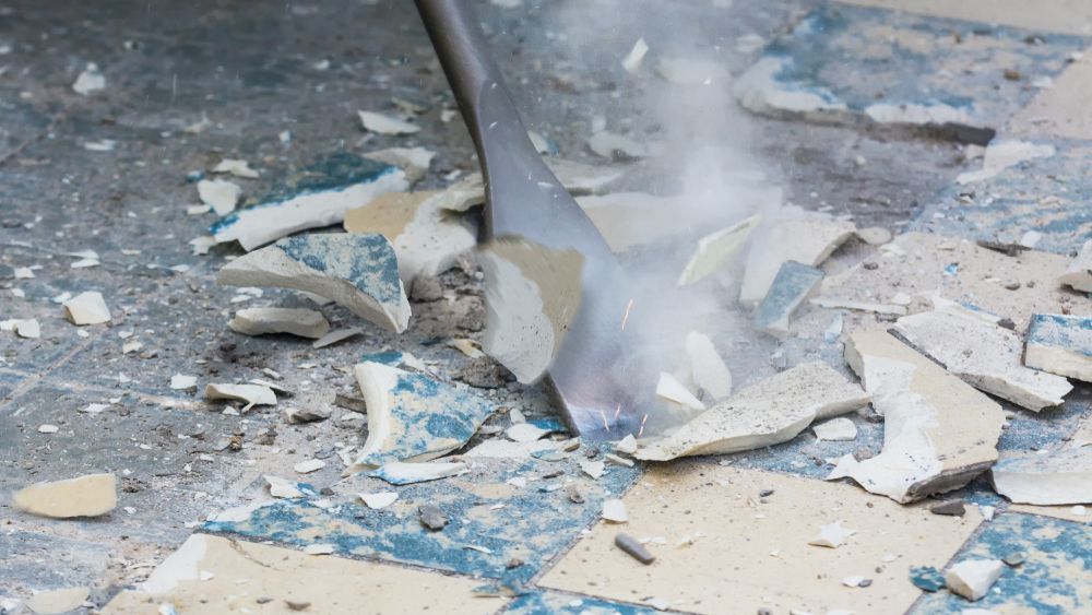 Chisel Breaking Blue and White Tile on a Gray Surface — Heller Excavation & Tree Services in Byron Bay, NSW
