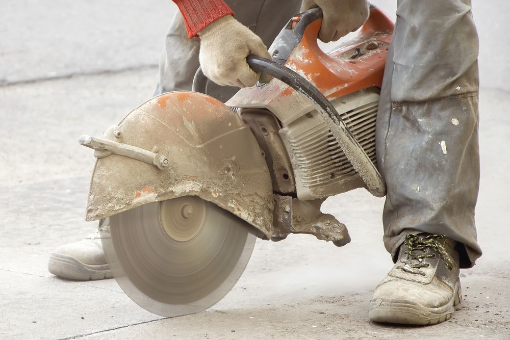 Construction Worker Using a Circular Saw to Cut Concrete — Heller Excavation & Tree Services in Byron Bay, NSW