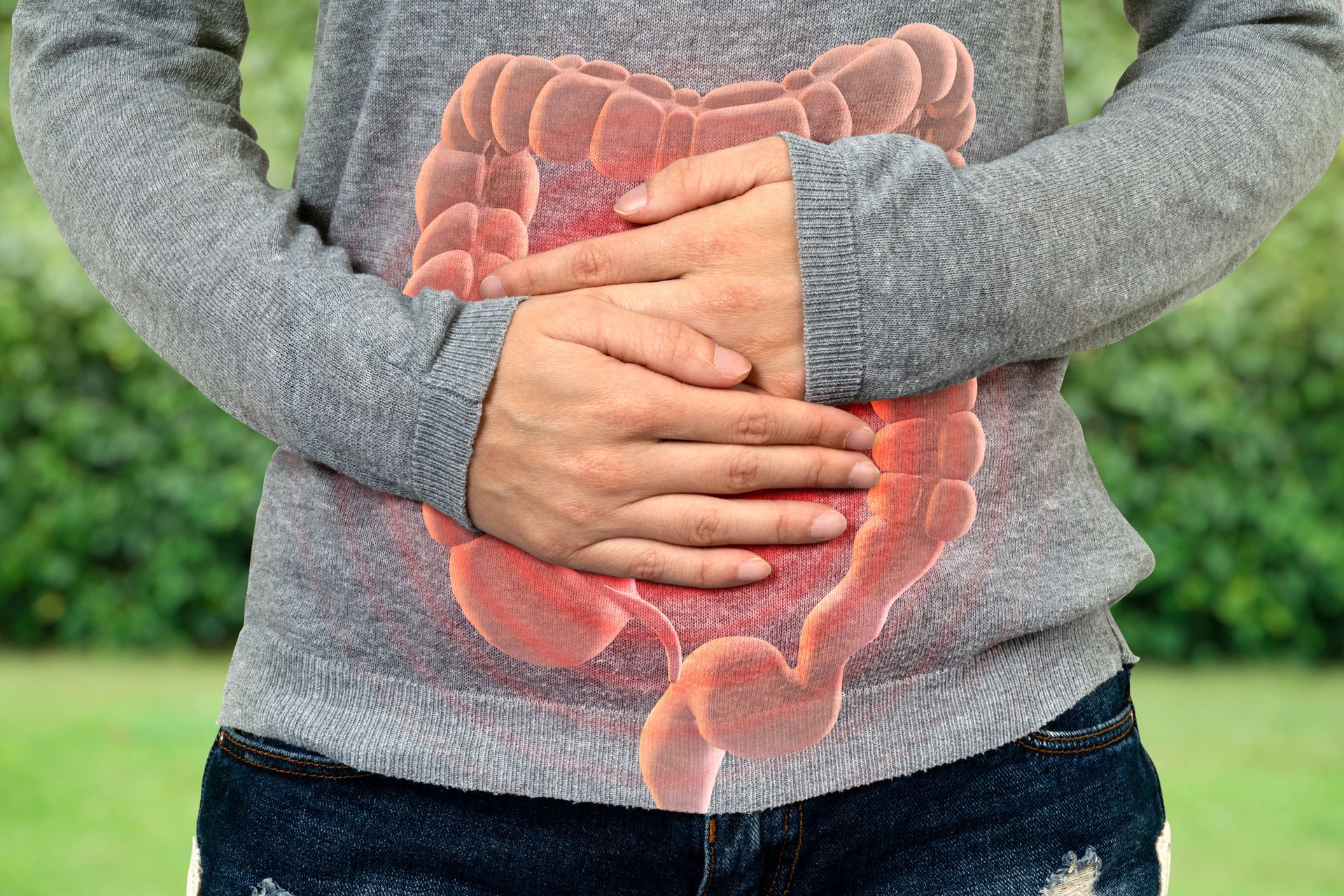 A woman is holding her stomach with her hands.
