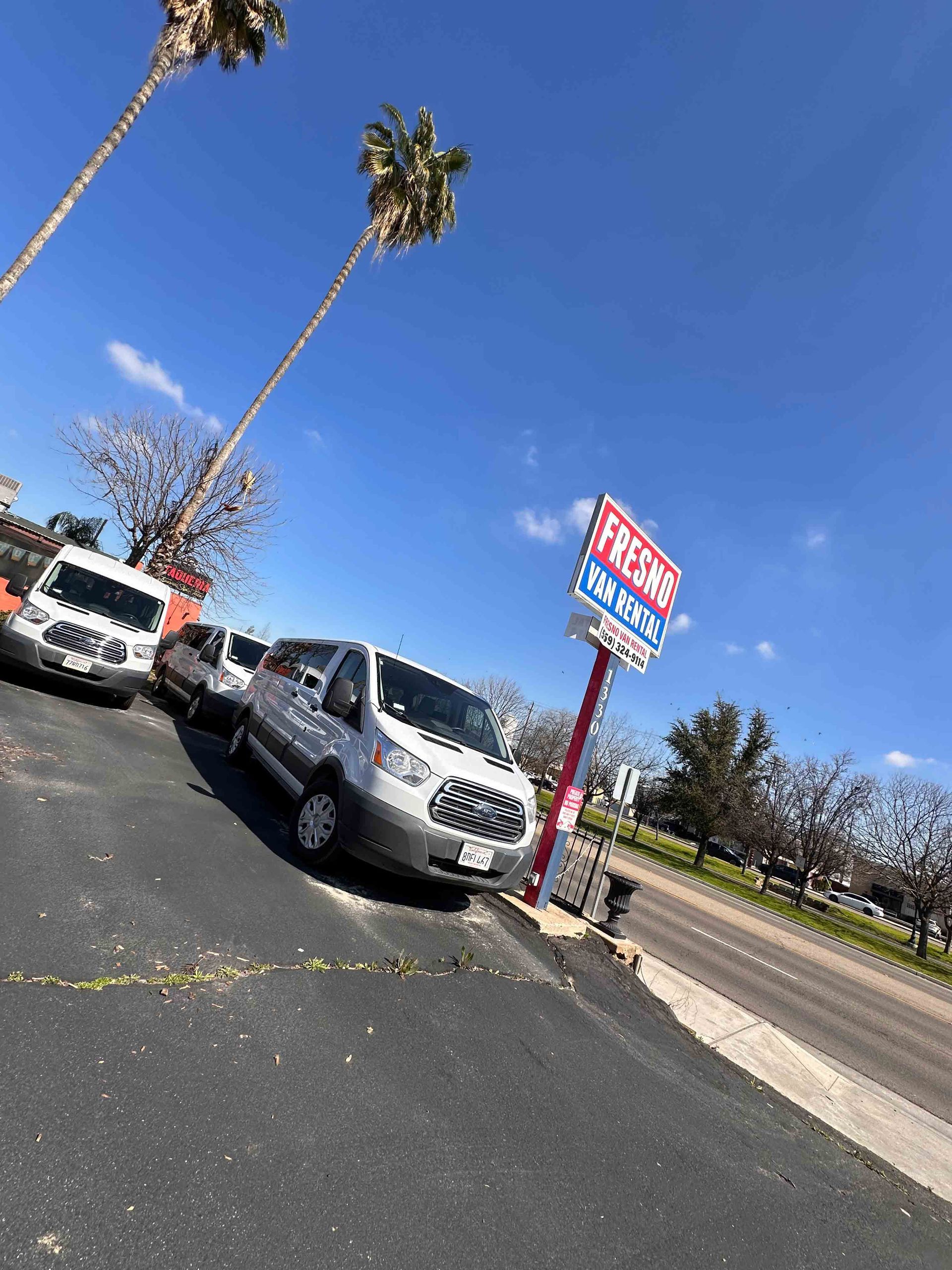 White Vans Parked In Front Of The Fresno Van Rental Signage — Clovis, CA — Fresno Van Rental