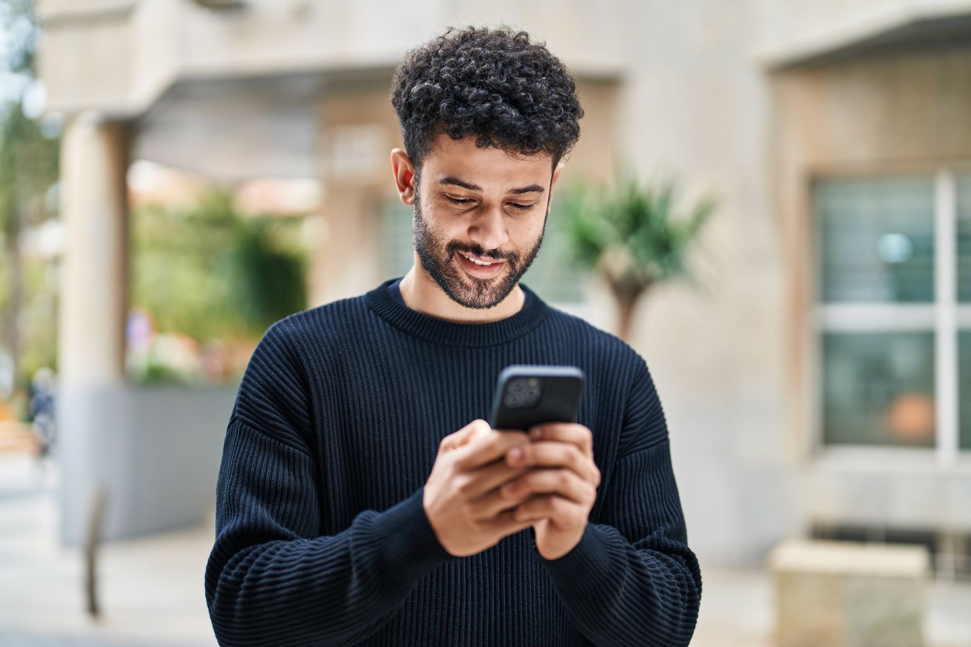 Founder smiling at his phone as new inquiries come in