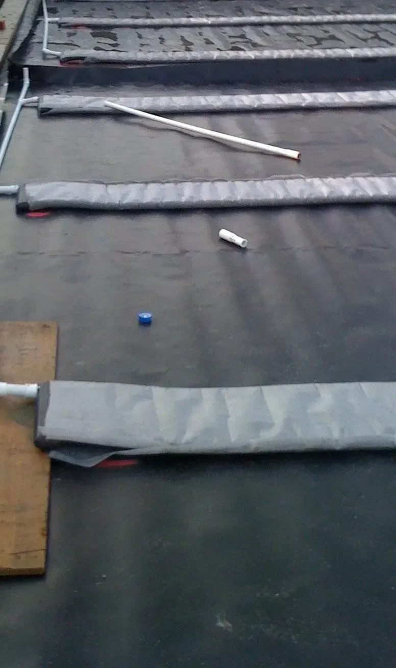 Gray padded mats and poles on a black floor, with a small blue ball near the center.