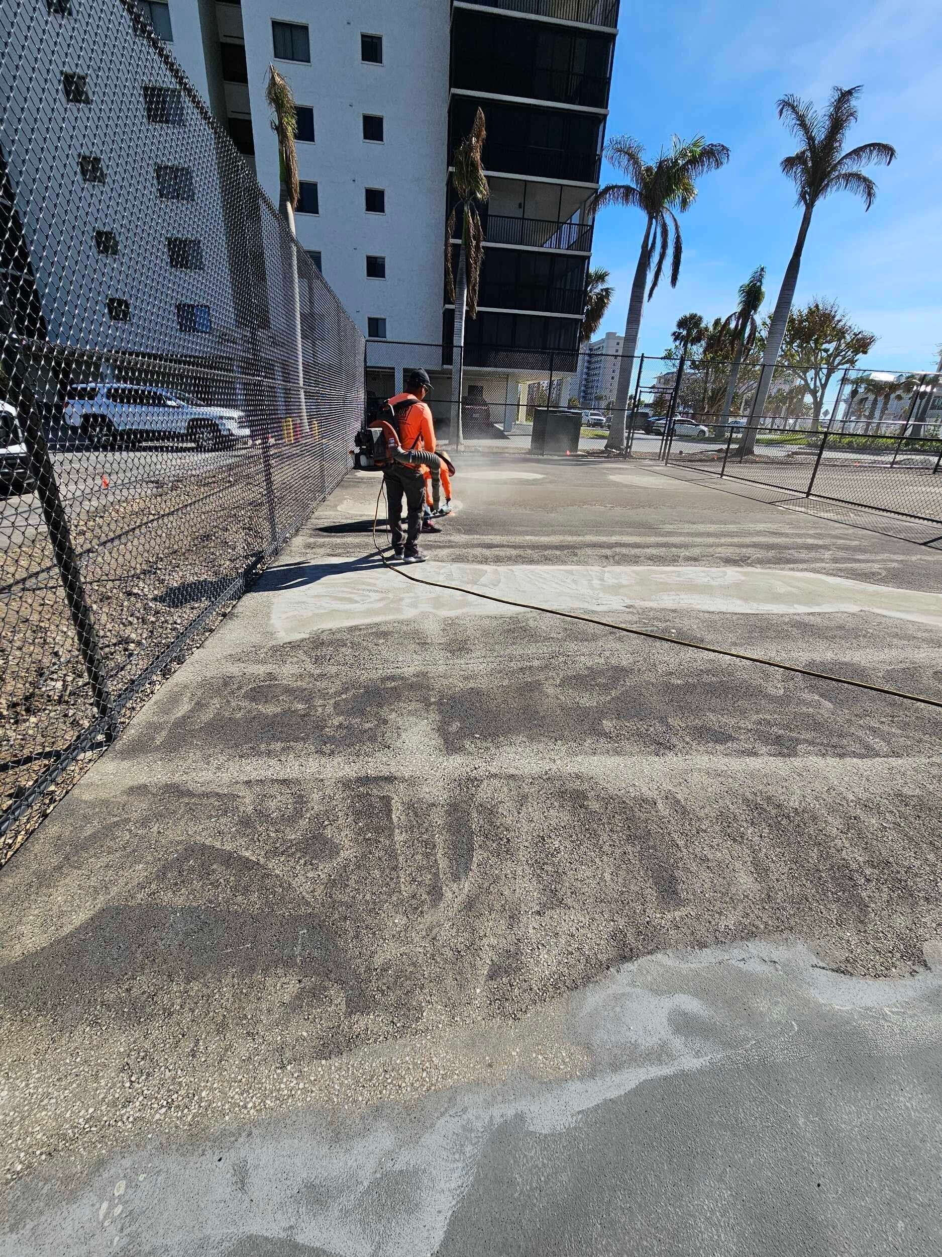 Worker in orange vest beside a damaged building and cracked ground at a construction site