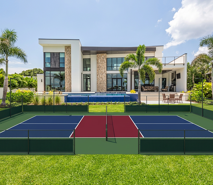 Modern house with a fenced backyard and a pickleball court in the foreground