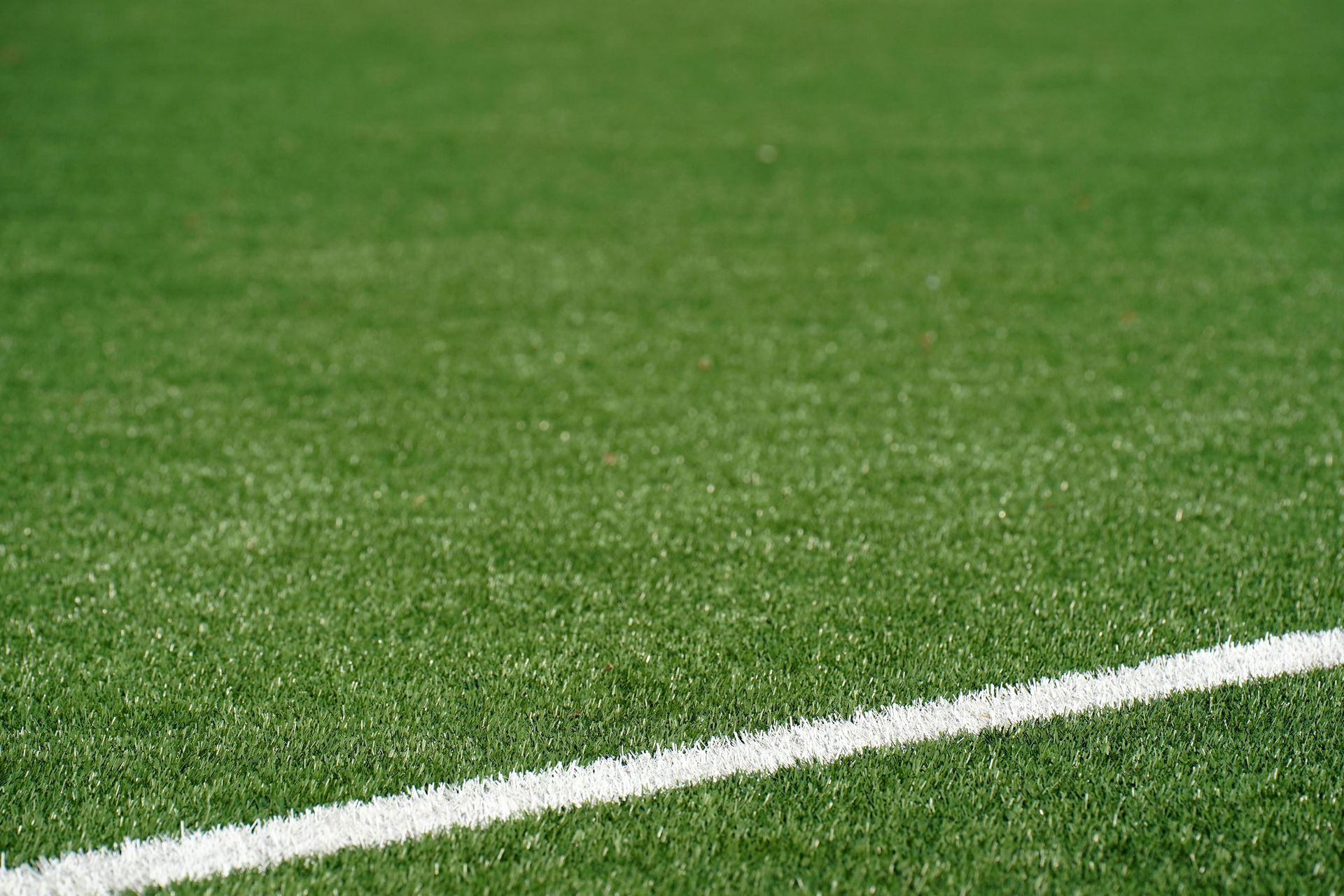Green sports field with a white boundary line