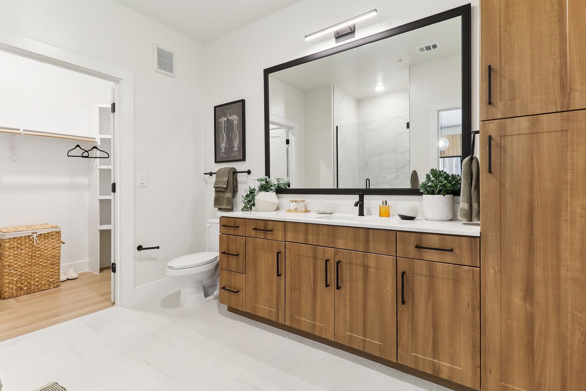 A bathroom with two sinks , a toilet , and a large mirror.