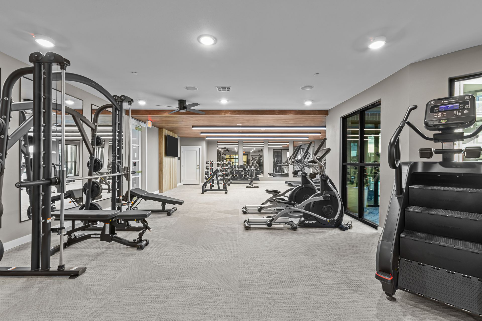A large gym filled with lots of exercise equipment.