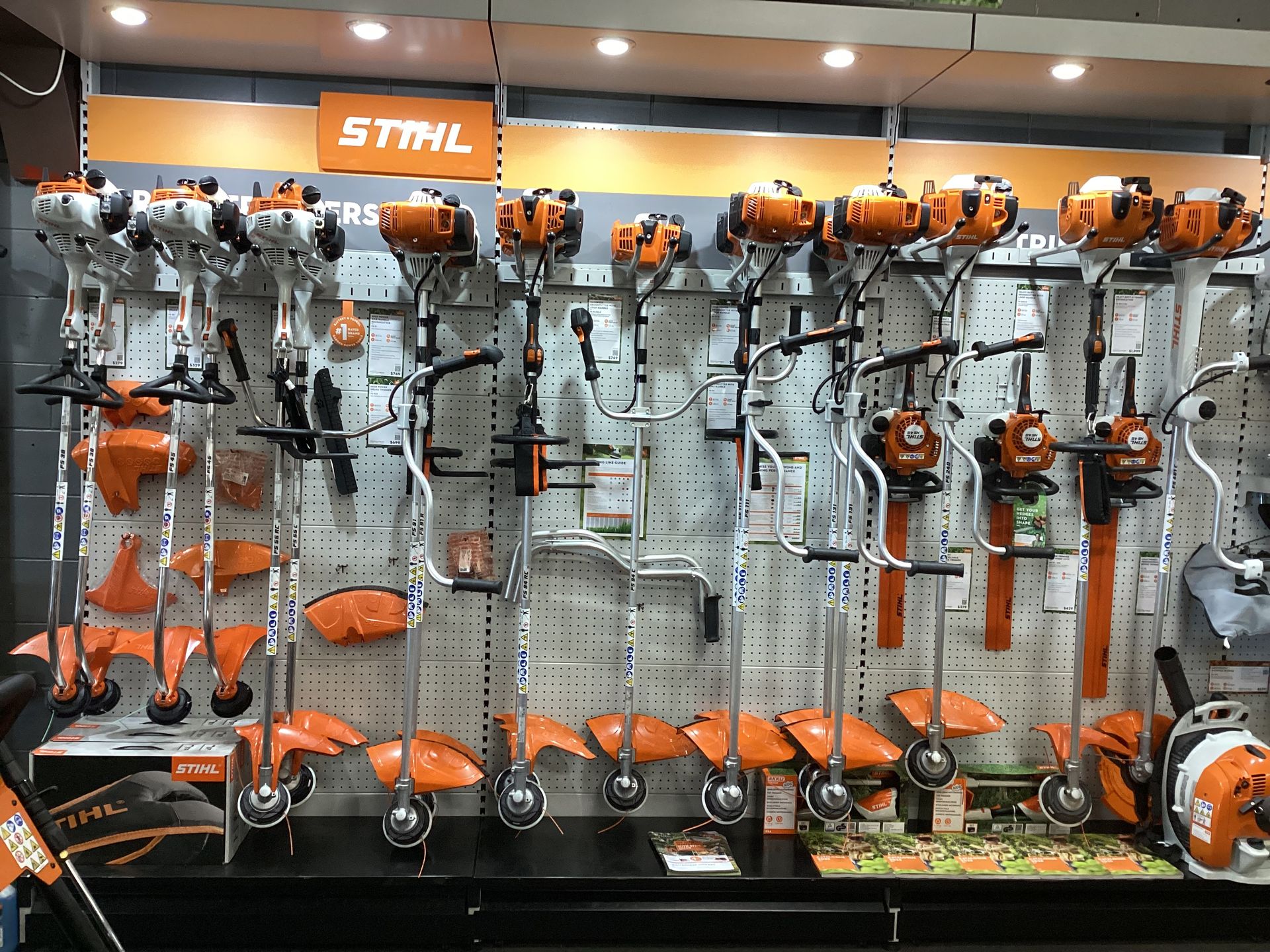 A Man Is Cutting A Hedge With A Hedge Trimmer — Whitsunday Mowers In Cannonvale, QLD