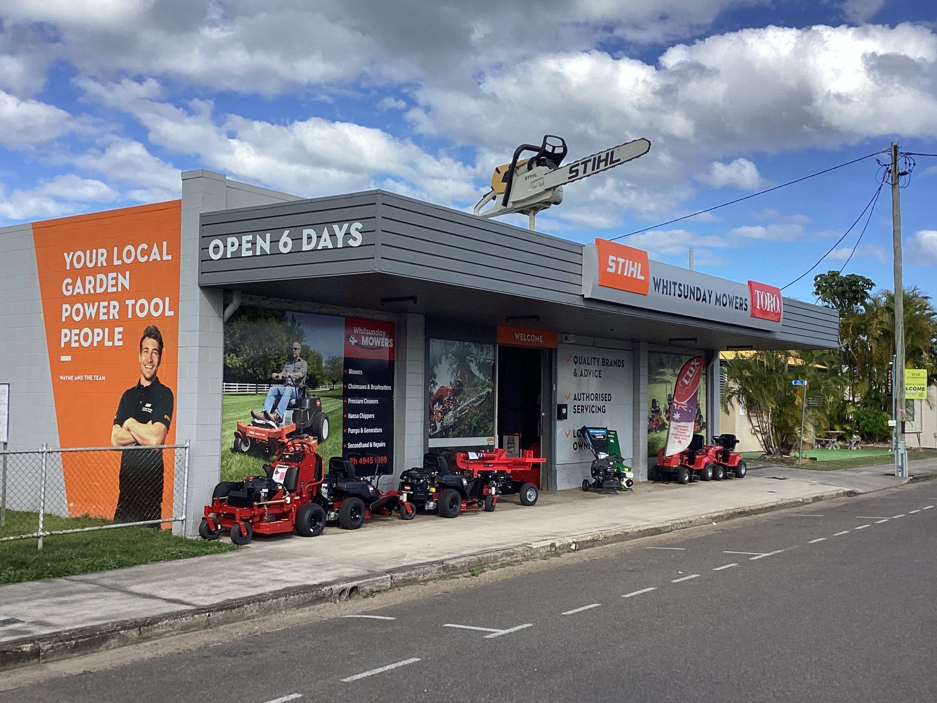 A Man Is Using A Lawn Mower On A Lush Green Lawn — Whitsunday Mowers In Cannonvale, QLD