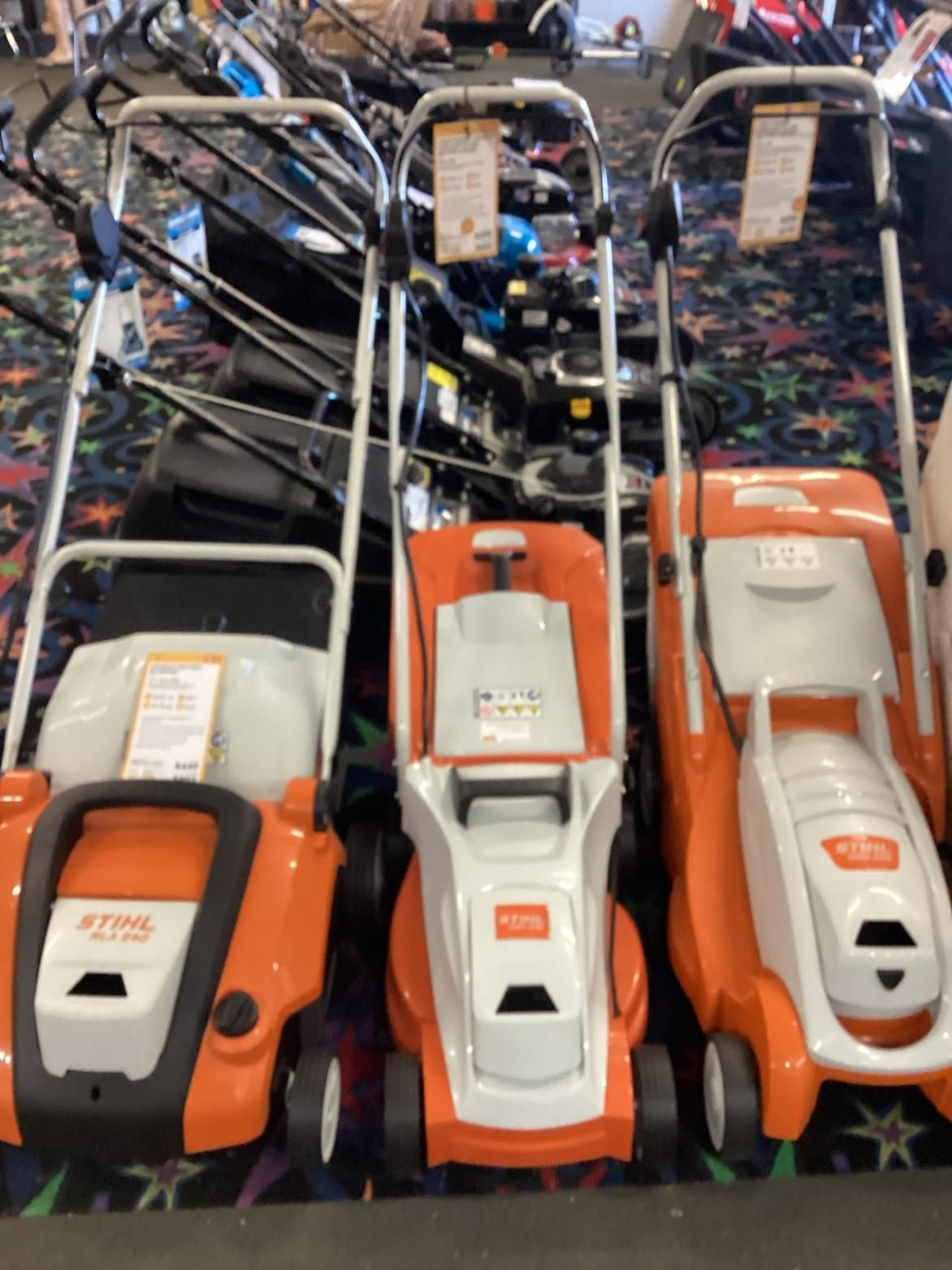 A Row Of Lawn Mowers Are Lined Up In A Store — Whitsunday Mowers In Cannonvale, QLD