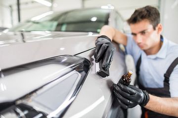 worker wiping the car