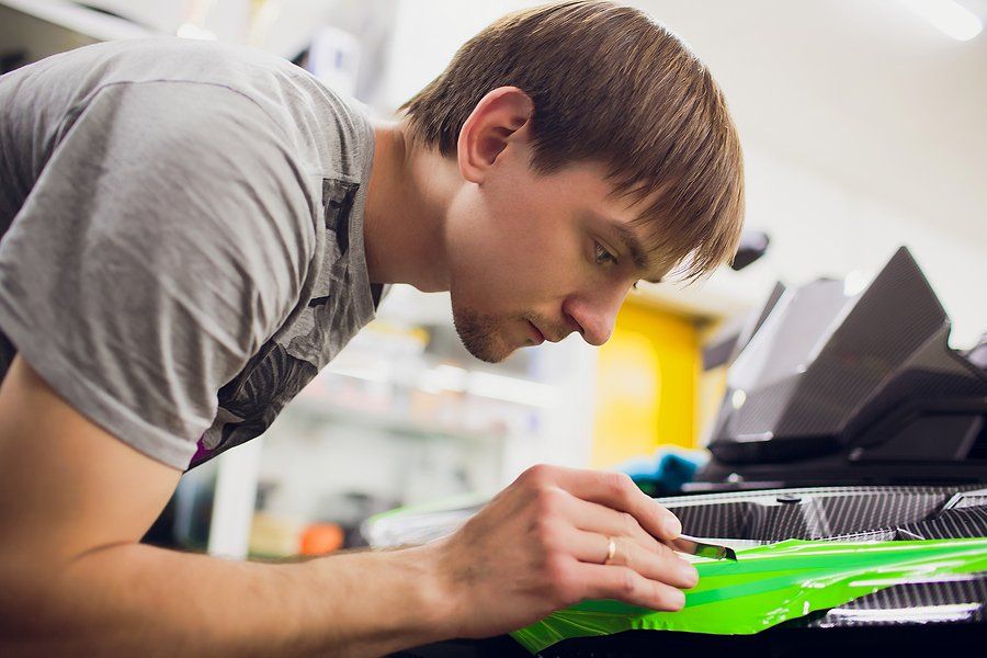 worker cutting the vinyl wrap