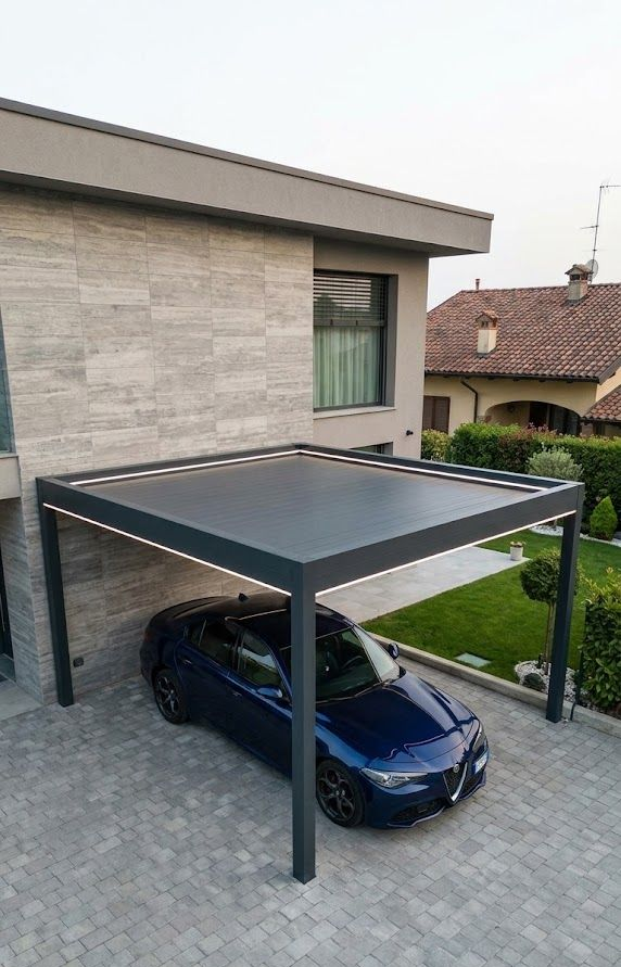 Un moderno ampliamento di un edificio con pareti in vetro, pilastri in mattoni, pavimento piastrellato e posti a sedere all'aperto.