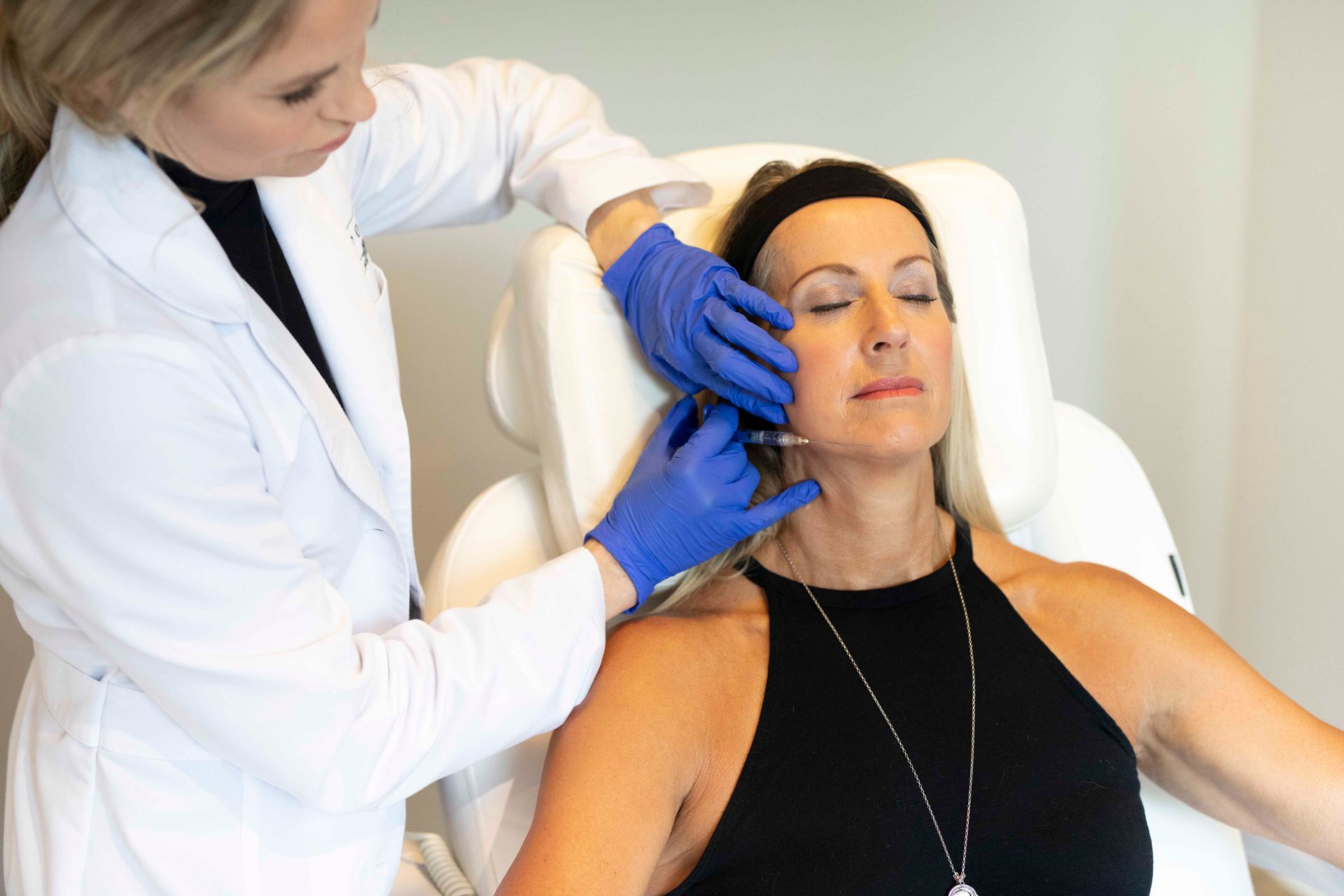 A woman is getting a botox injection in her face.