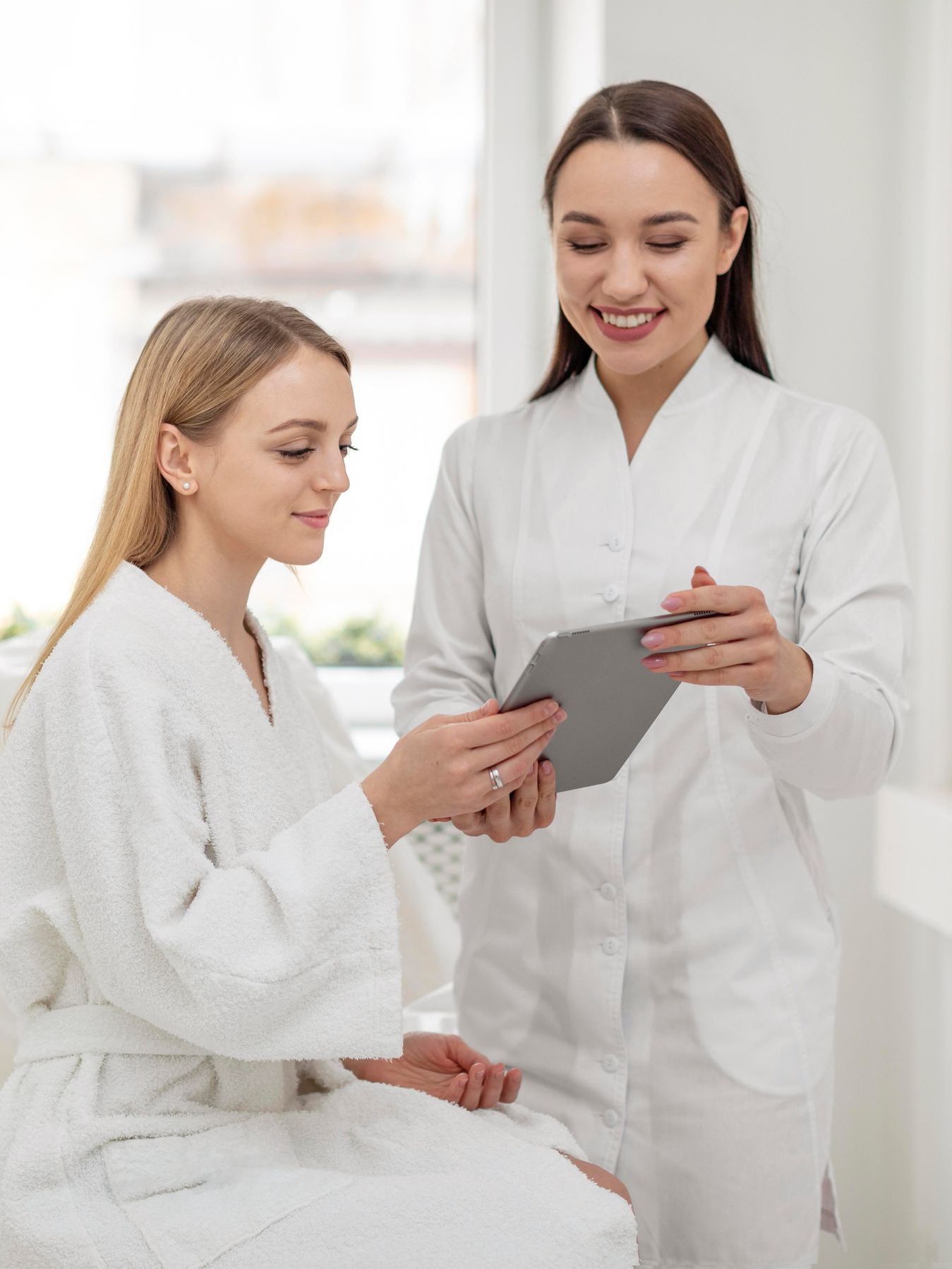 A female doctor is looking at a tablet with a patient.