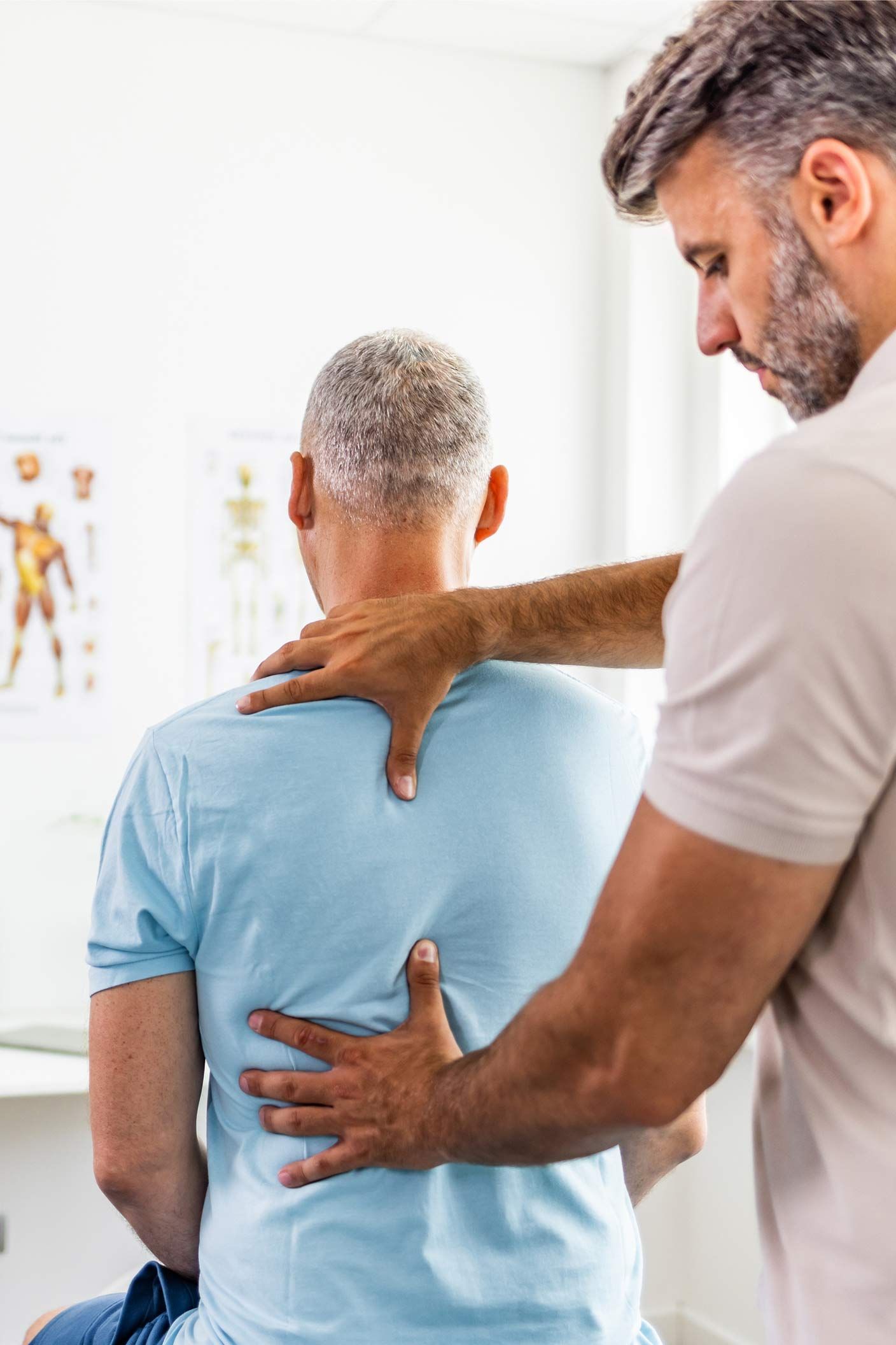 A man is giving an older man a massage on his back
