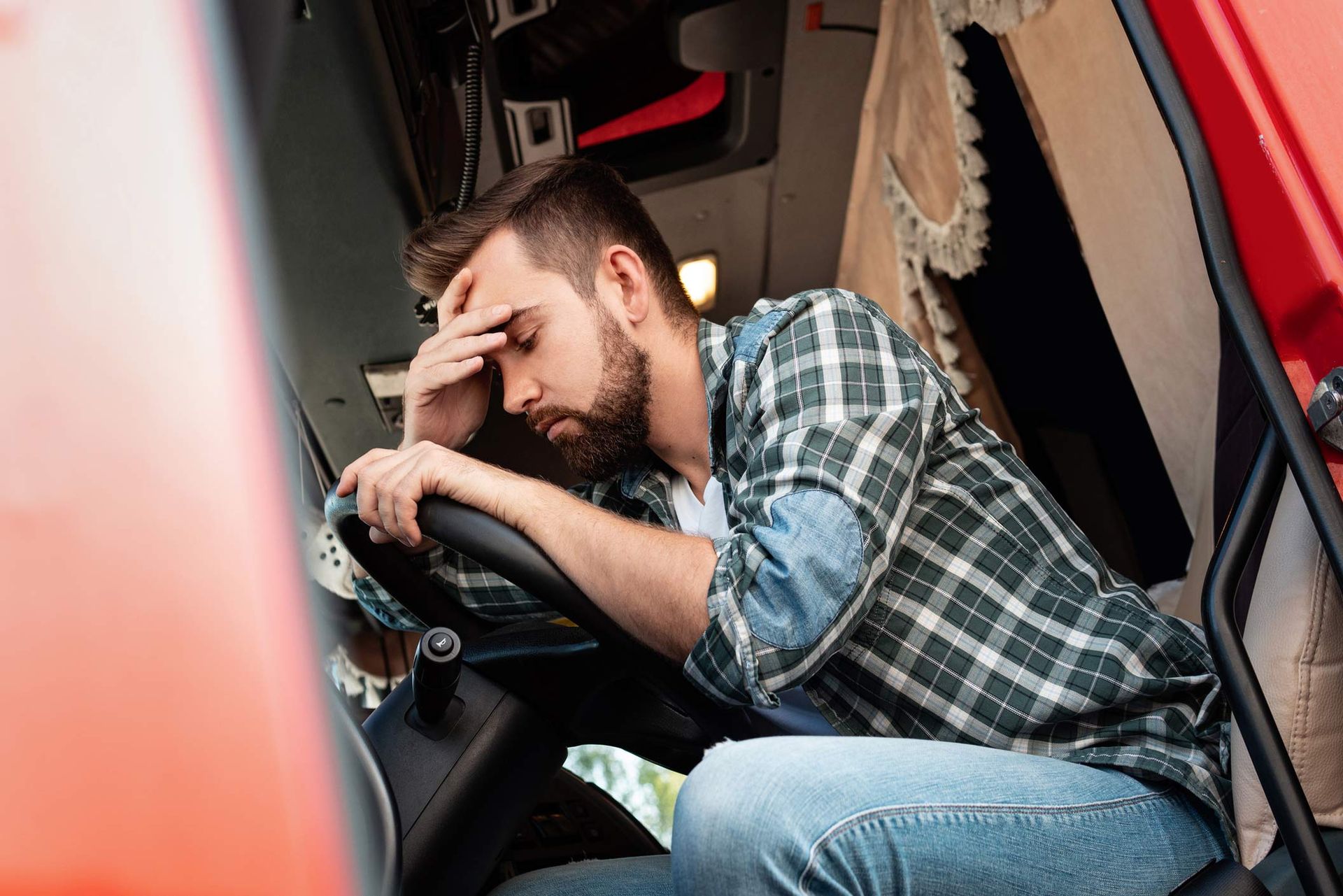 A man is sleeping in the driver 's seat of a truck
