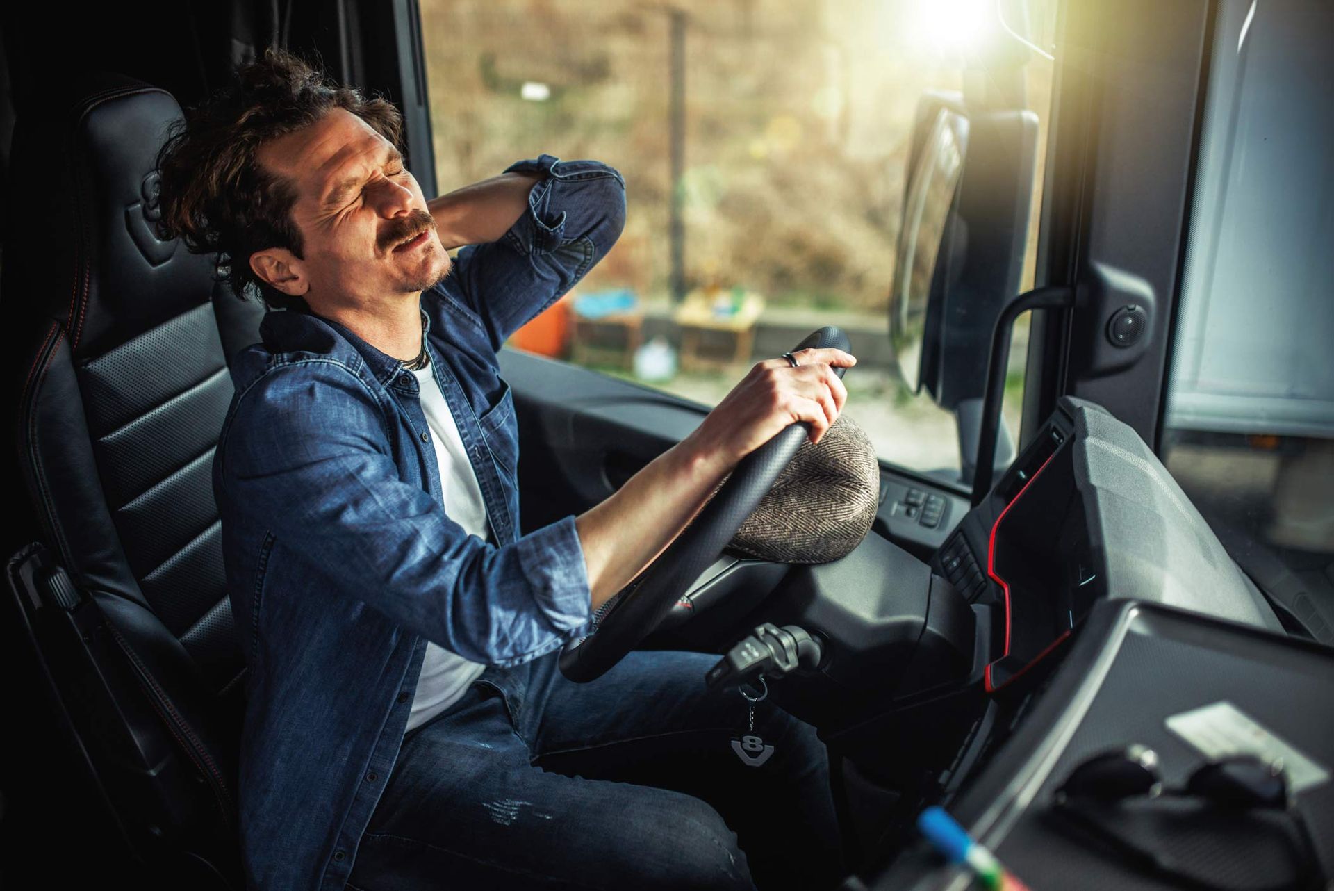 A man is sitting in the driver 's seat of a truck