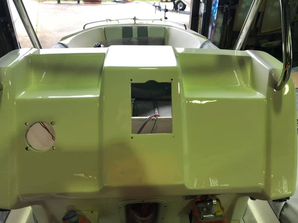 A Green And White Boat Is Sitting In A Garage — Murraycraft Fibreglass In Glenella, QLD