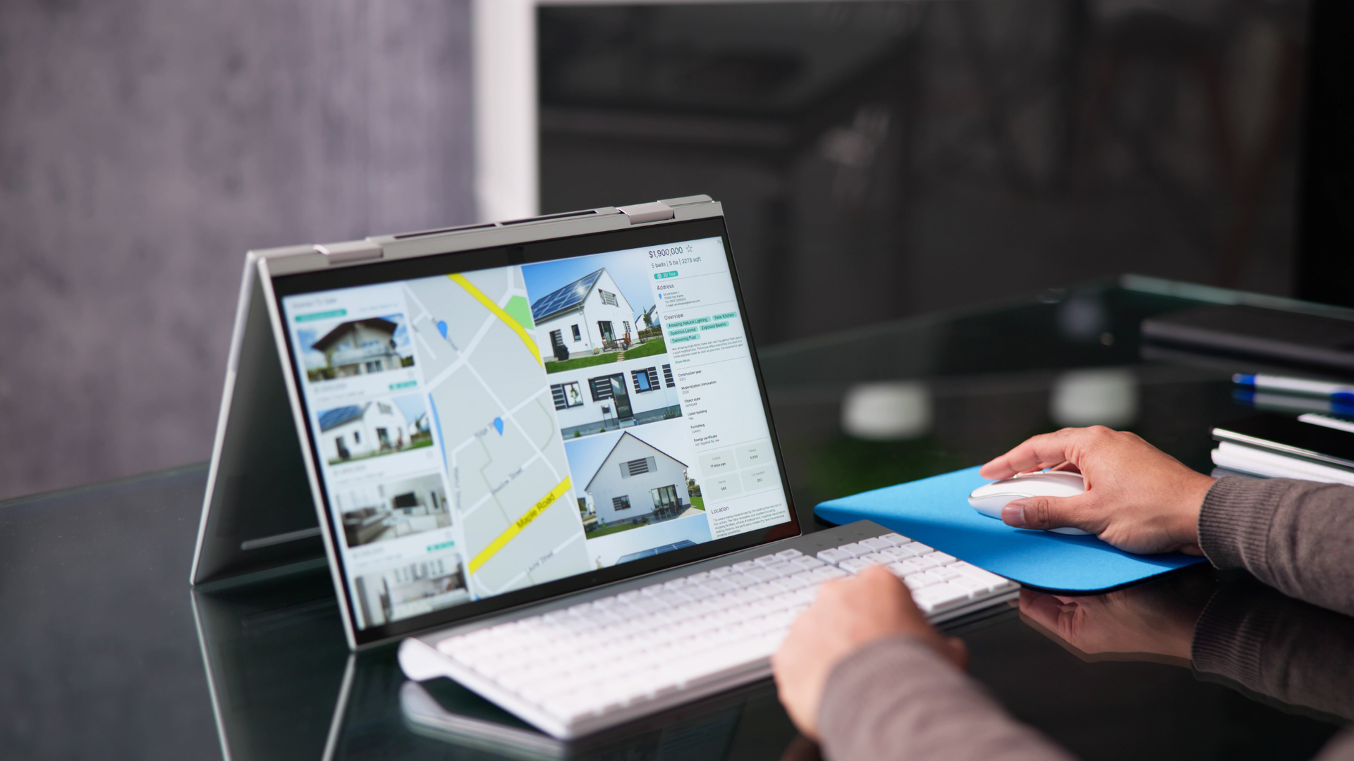 Someone scrolling through property listings on a laptop screen