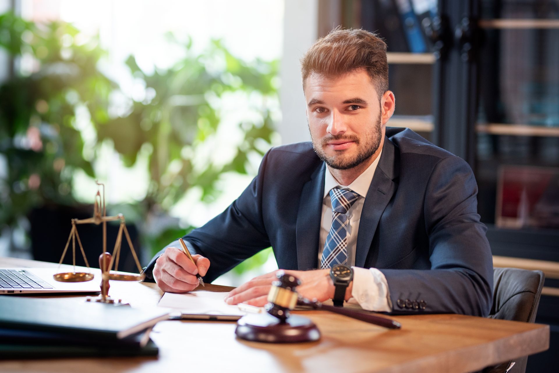 Business litigation lawyer at desk with scales of justice and gavel.