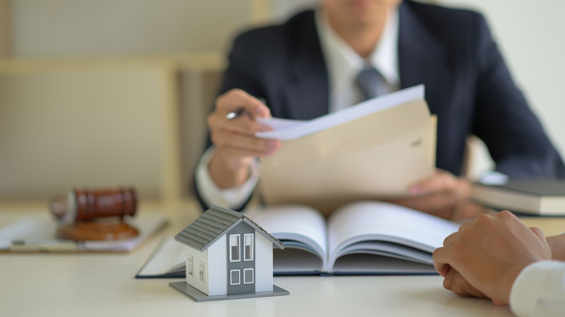 a person in a suit reviewing documents, suggesting real estate or legal consultation.