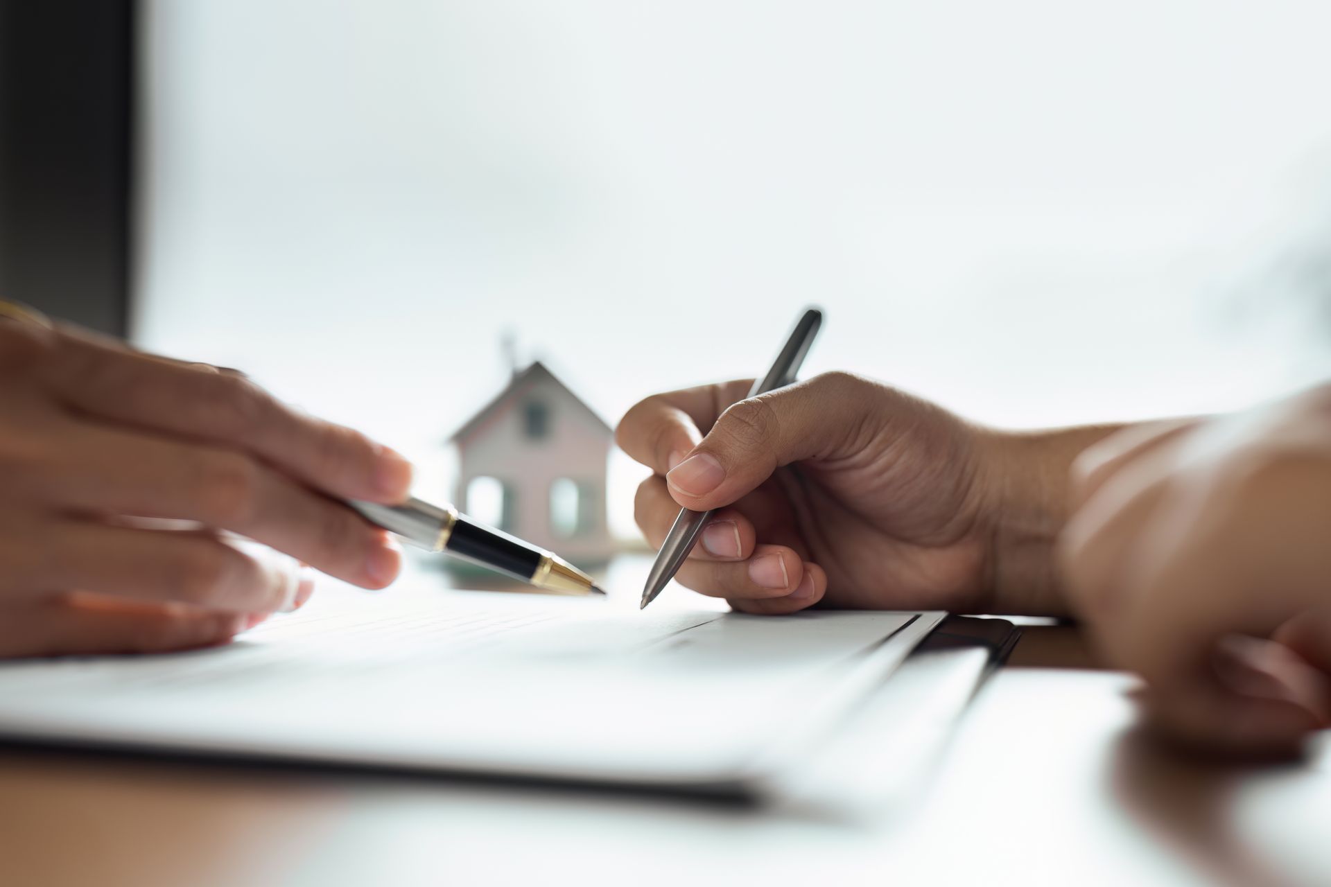 Real estate client signing property purchase agreement with agent assistance Real estate client signing property purchase agreement with agent assistance