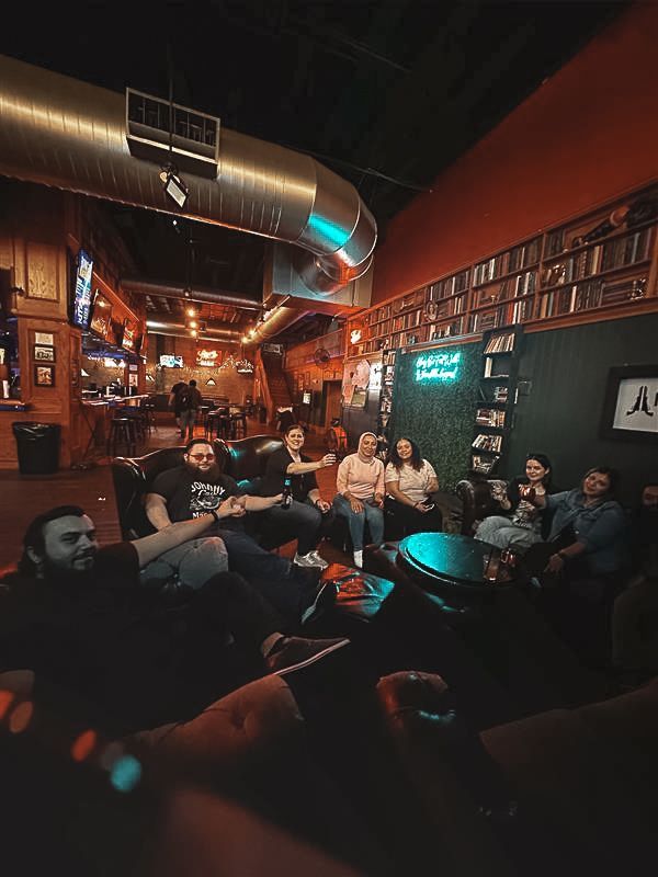 A group of people are sitting around a table in a restaurant.