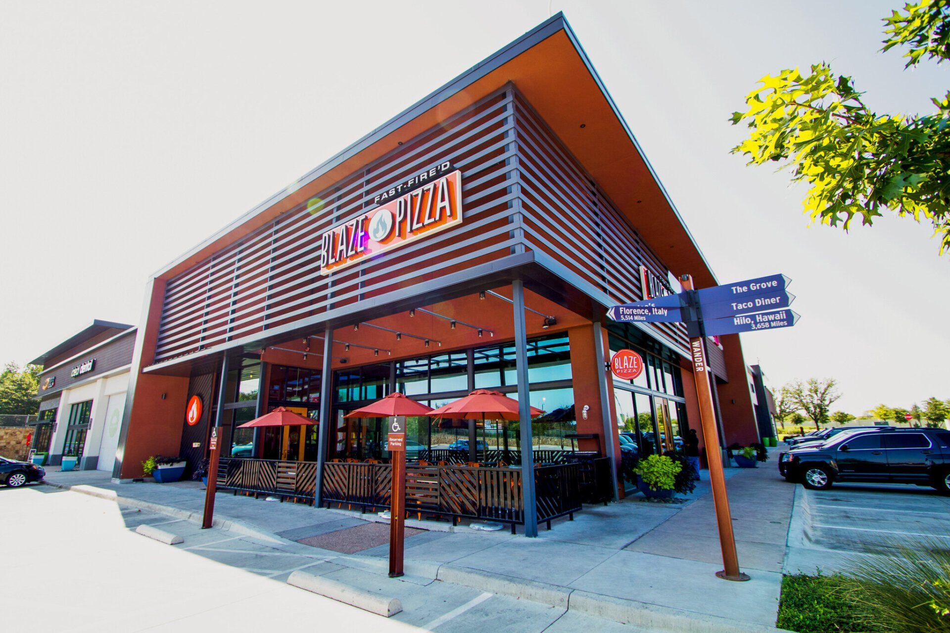 The outside of a restaurant with umbrellas and tables