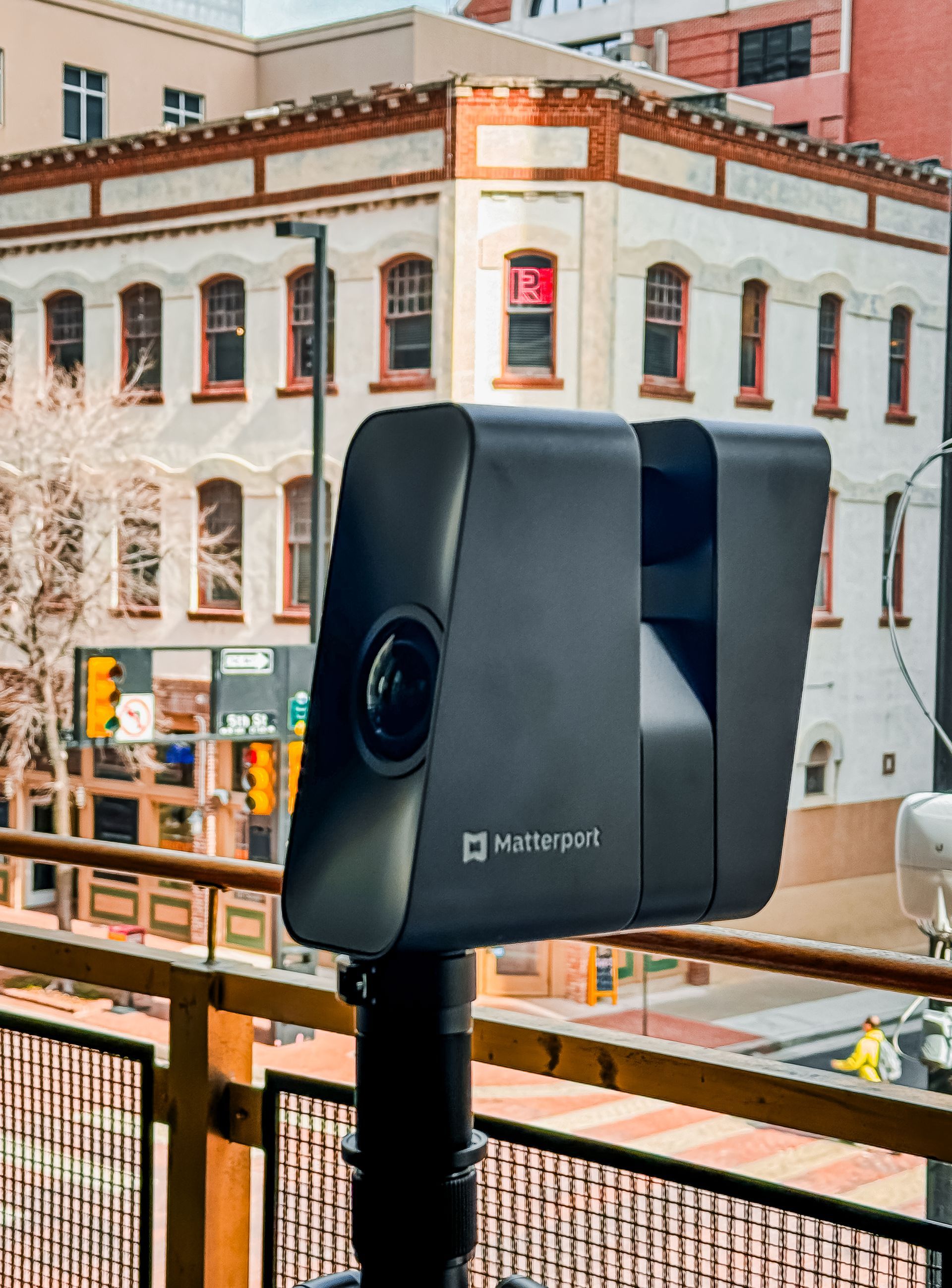 A camera on a balcony with a building in the background