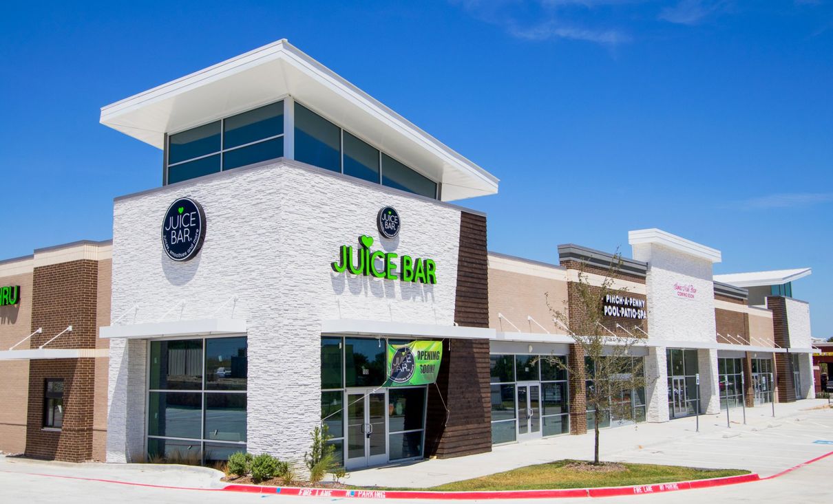A large building with a lot of windows and a sign that says juice bar on it.