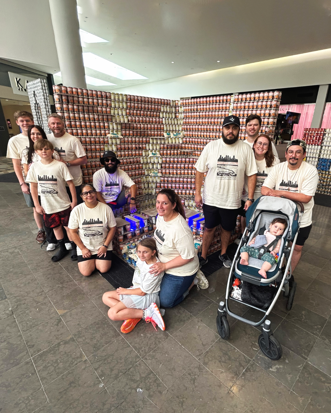 Photo of the Rogue Architects Team in front of a structure made out of cans for Canstruction Fort Worth