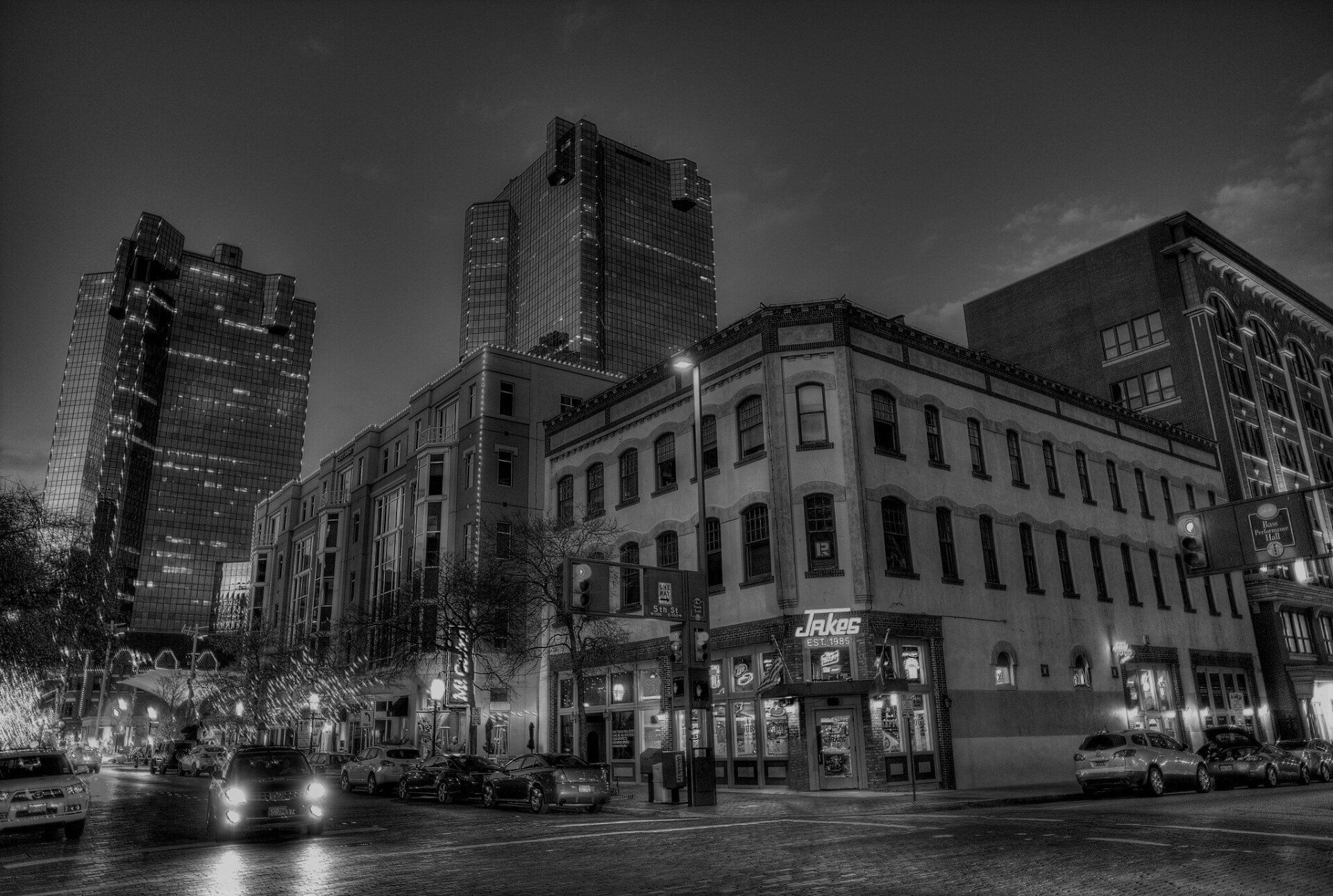 A black and white photo of a city street at night.
