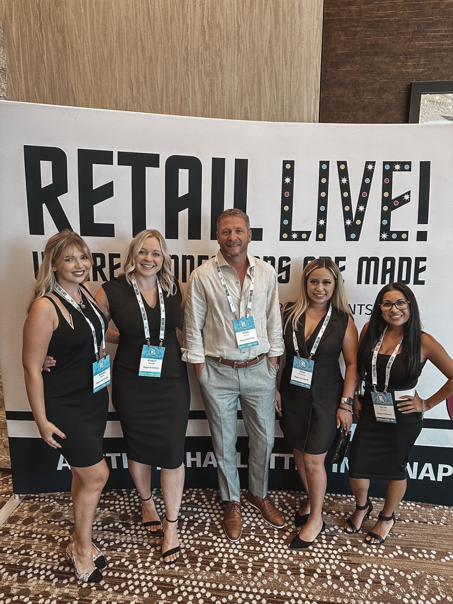 A group of people standing in front of a sign that says retail live