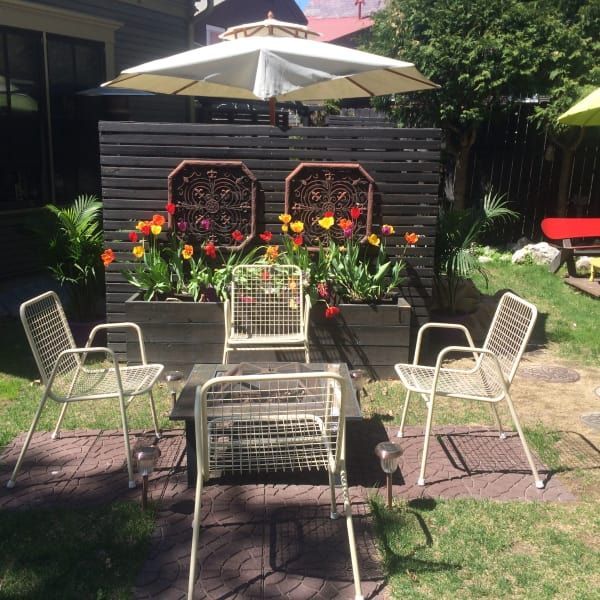 A table and chairs under an umbrella in a backyard
