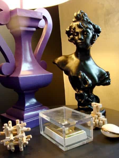 A purple lamp sits next to a black bust of a woman