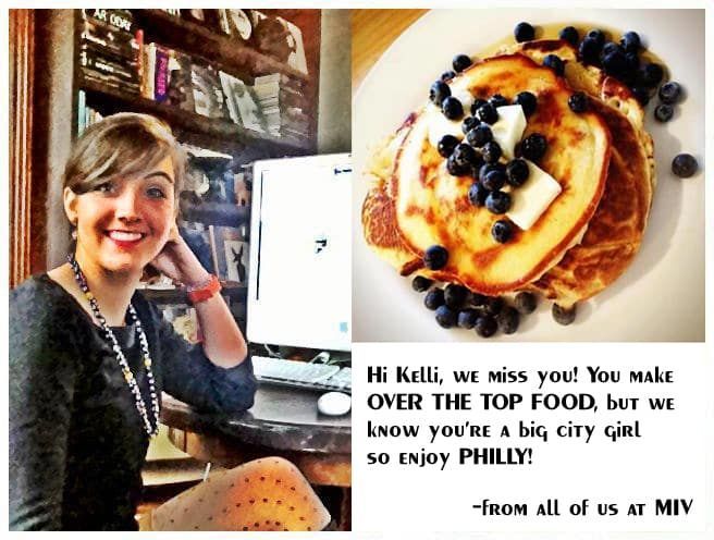 A woman is smiling next to a plate of pancakes with blueberries