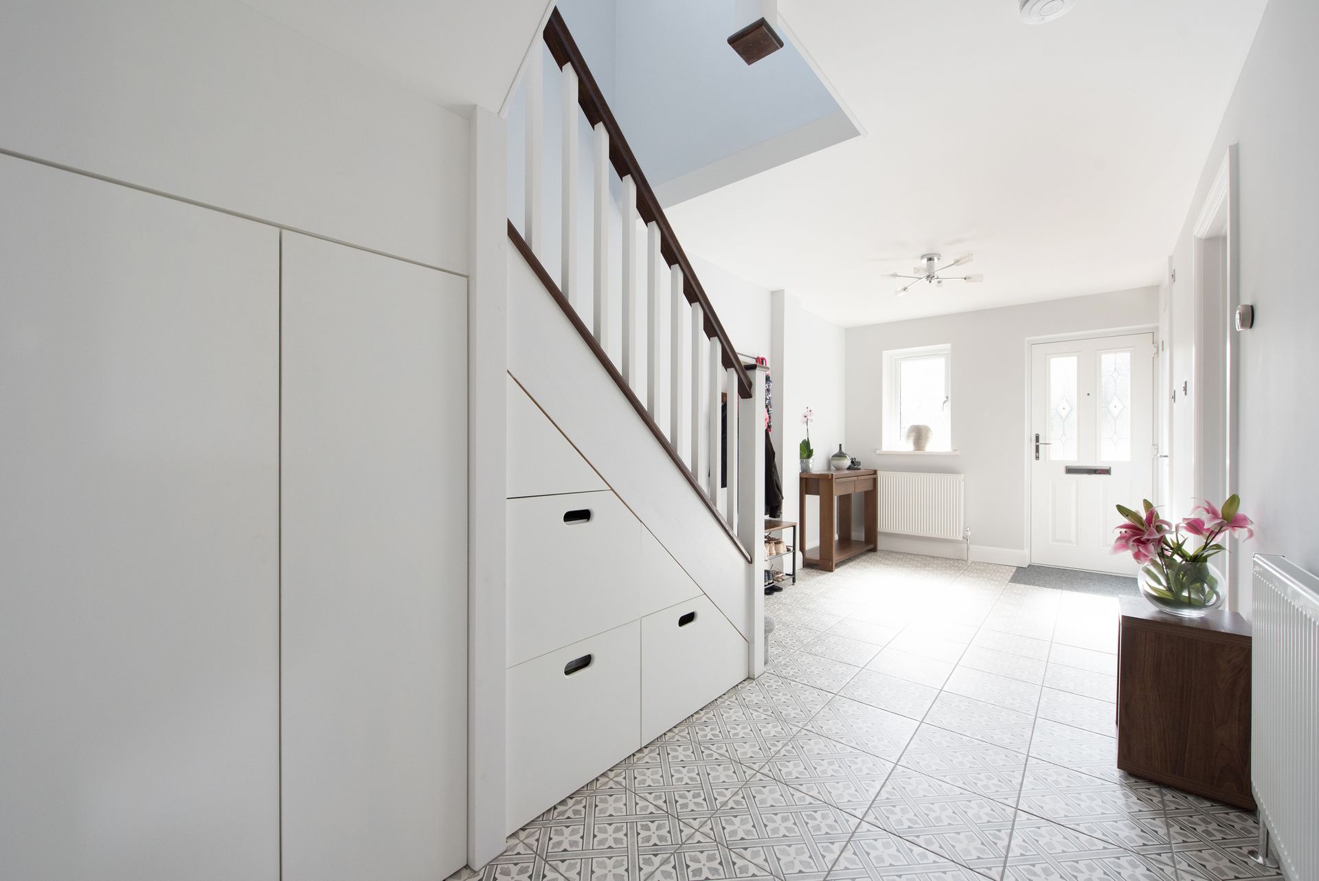 Kitchen with a large island, white cabinets, granite countertops, and wood floors.