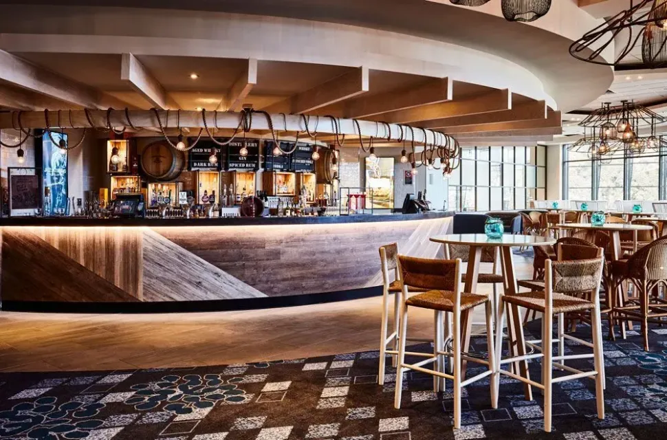 A restaurant with tables and chairs and a bar.