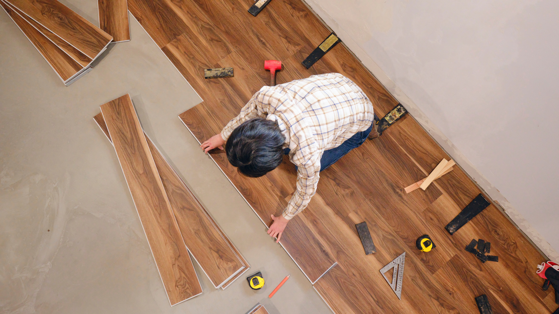 Rolled-up blueprint, yellow hard hat, safety glasses, and level; construction tools.