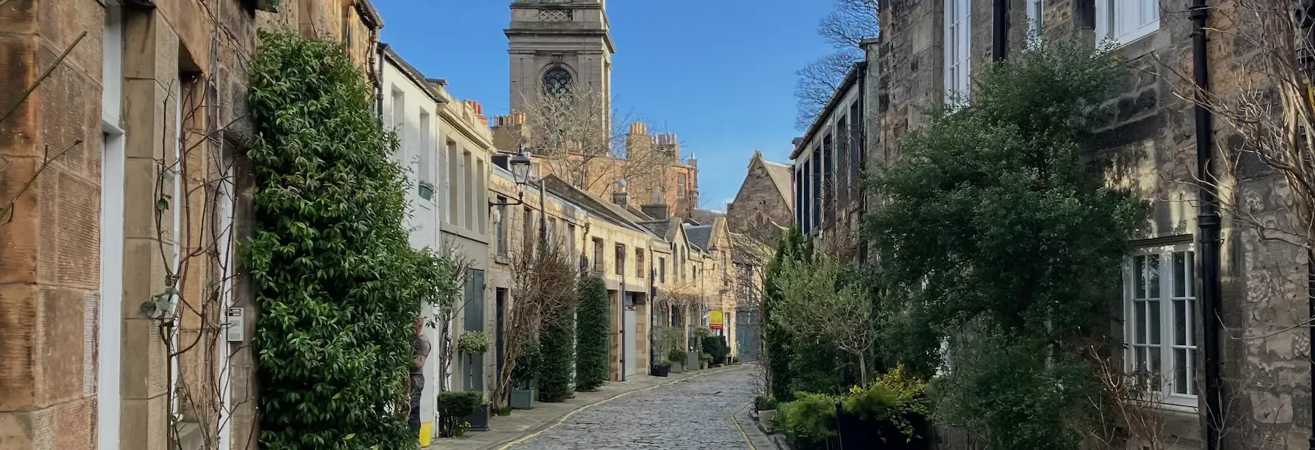 Stone houses and floral displays on Circus Lane, a picturesque spot on an Edinburgh architectural walking tour.