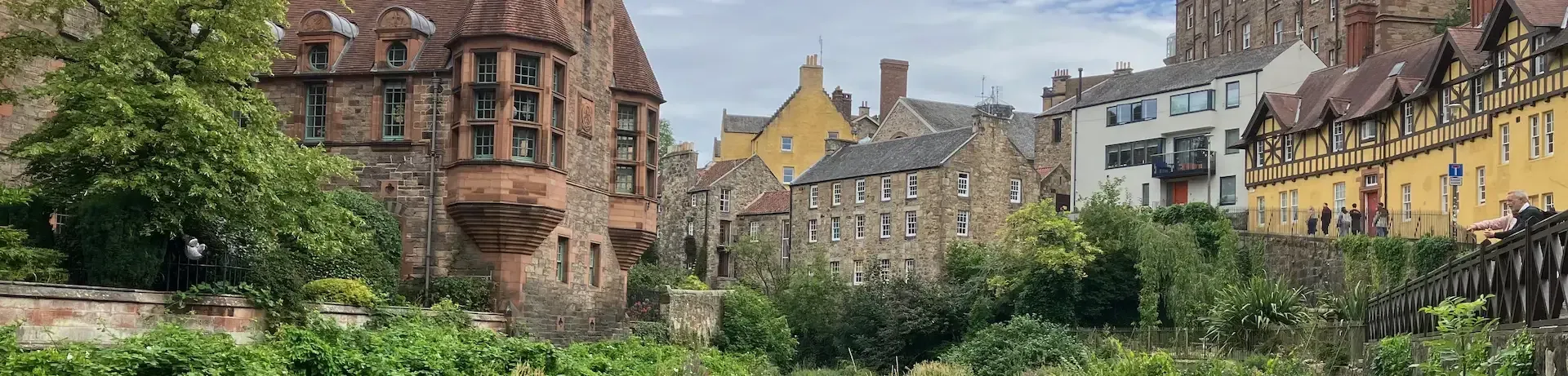 Scenic view of Dean Village stone houses and the Water of Leith during an educational Edinburgh walking tour.