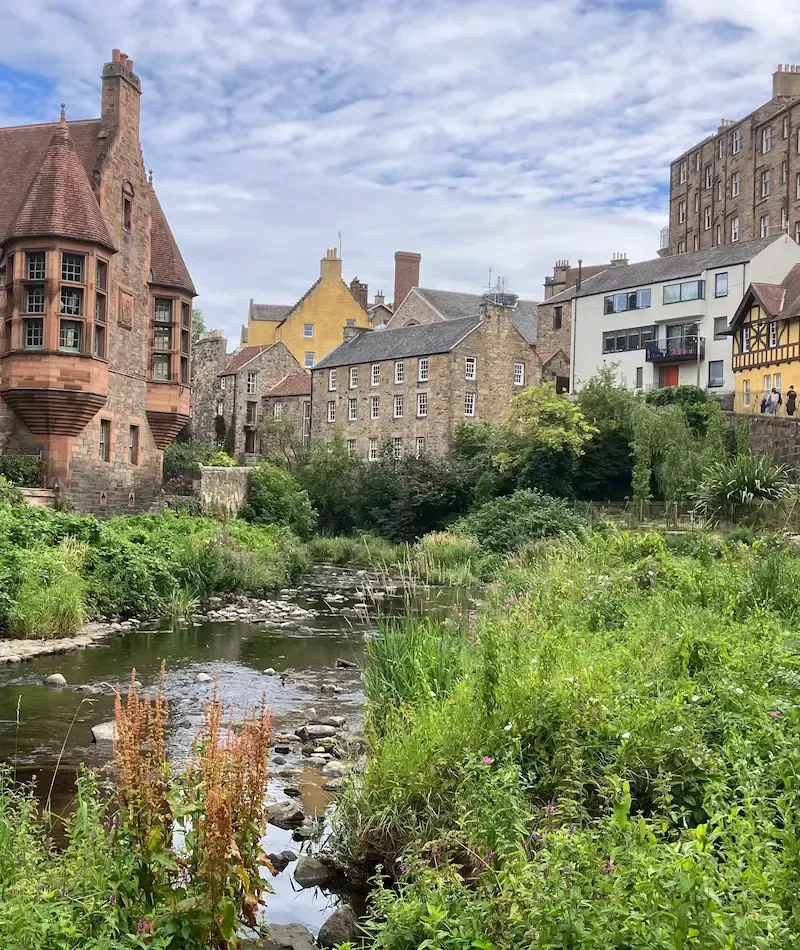 Scenic view of Dean Village stone houses and the Water of Leith during an Edinburgh walking tour.