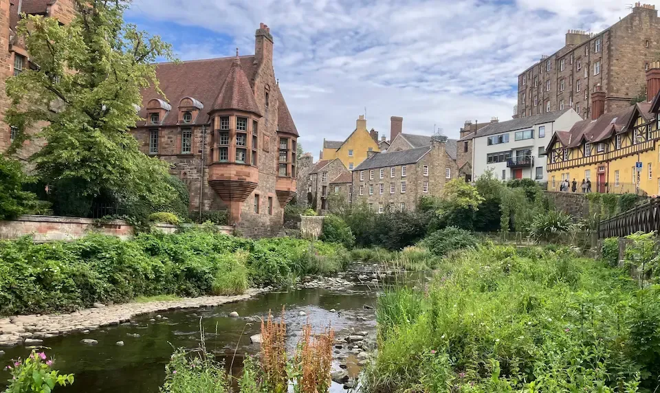 Scenic view of Dean Village stone houses and the Water of Leith during a private Edinburgh walking tour.