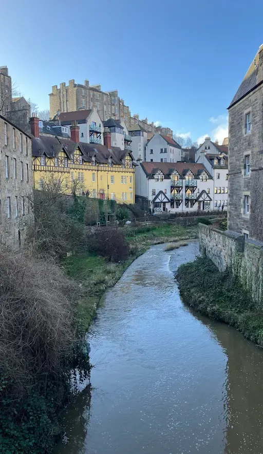 Picturesque view of Dean Village stone houses and the Water of Leith during an Edinburgh Architectural Walking Tour.