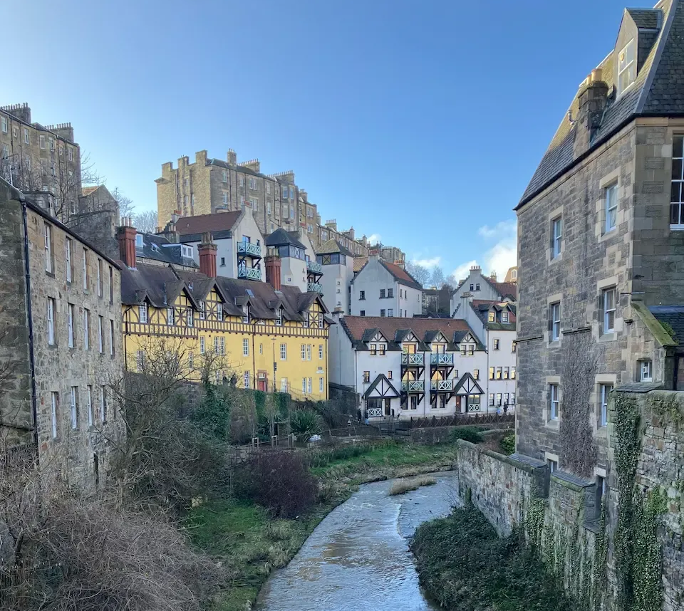 Picturesque view of Dean Village stone houses and the Water of Leith during an Edinburgh Architectural Walking Tour.