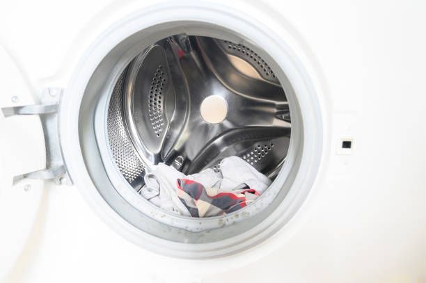 A close up of a washing machine with clothes in it.| Kansas City, KS | APA