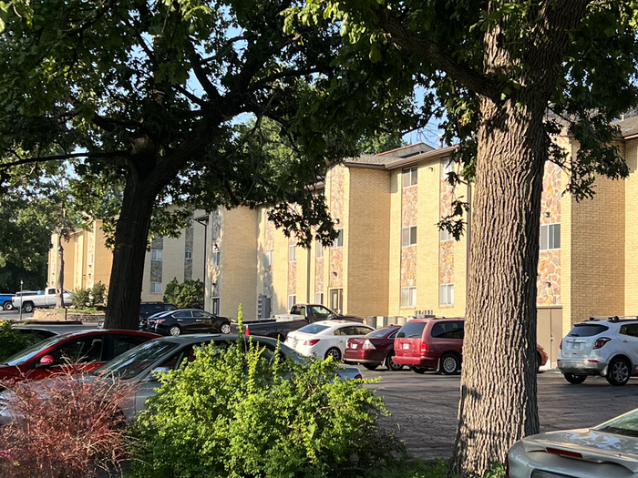 A parking lot with cars parked in front of a building.| Kansas City, KS | APA A parking lot with cars parked in front of a building.| Kansas City, KS | APA